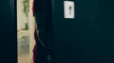 Genç Afrikalı kadın kapıyı açar ve teslimatı kabul eder.