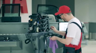 Görevli motorlu teknede yağ kontrolü yapıyor.