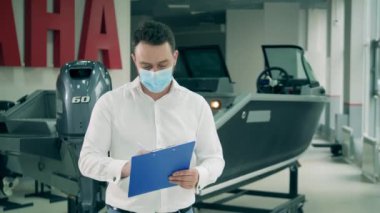 Tekne dükkanındaki satıcı maske takıyor.