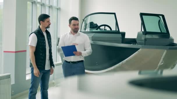 Hombre vendedor está hablando con un cliente acerca de un barco — Vídeos de Stock