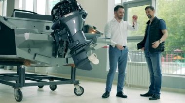 Satıcı, motorlu teknenin anahtarlarını bir müşteriye verir.