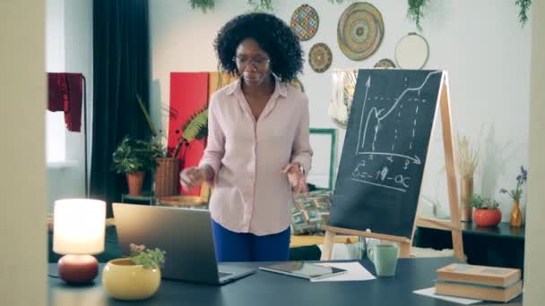 African lady is explaining a diagram during her online lesson — Stock Video