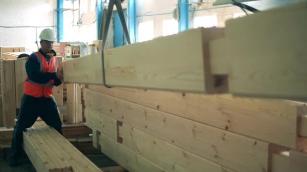 Промышленный работник помогает транспортировать деревянный балк — стоковое видео