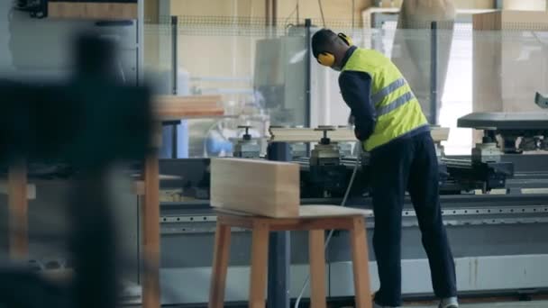 Le travailleur de l'usine pulvérise des produits chimiques sur la machine industrielle