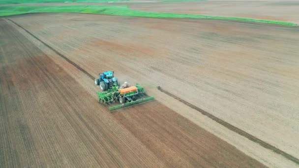 Bovenaanzicht van een zaaimachine die het veld zaait — Stockvideo