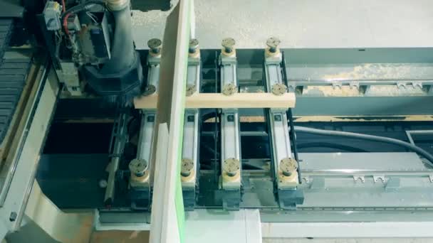 Klein stukje hout wordt verwerkt door een industrieel mechanisme — Stockvideo