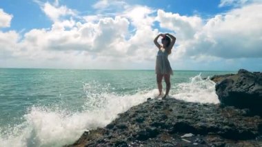 Muhteşem bayan kayalık okyanus kıyısında mutlu.