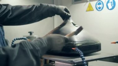 Fabrika işçisi TV 'yi çekiçle yok ediyor.