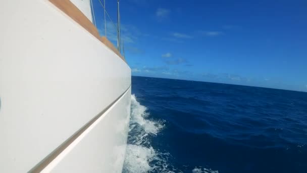 Tablero blanco de un yate a la deriva en aguas azules — Vídeos de Stock