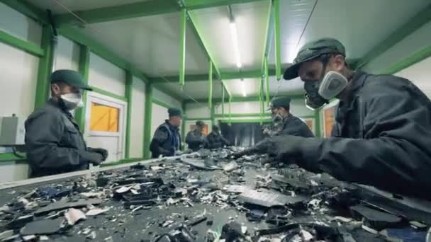 Mannen sorteren metalen afval op een transportband. — Stockvideo