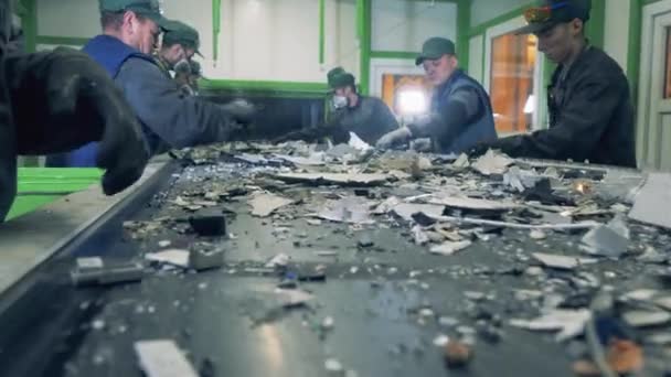 Mannelijke werknemers scheiden afval in een recyclingfabriek. — Stockvideo