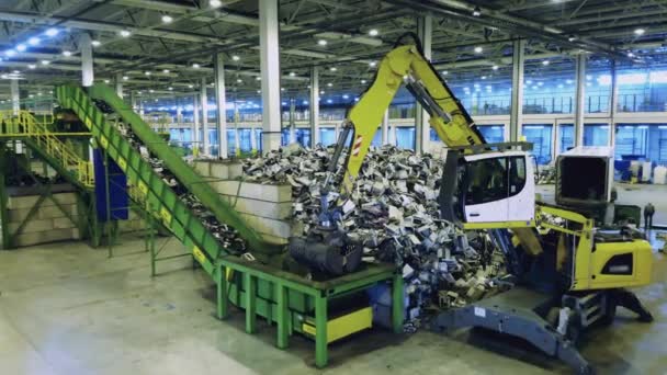 La macchina industriale mette la spazzatura nel contenitore di una fabbrica. Spazzatura di plastica alla fabbrica di riciclaggio dei rifiuti. — Video Stock