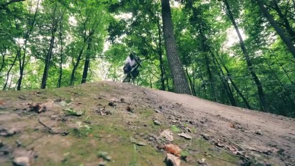 Uma pessoa está andando de bicicleta sobre um obstáculo com um salto — Vídeo de Stock