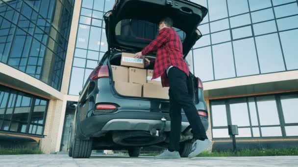 El repartidor toma cajas de su maletero. — Vídeo de stock