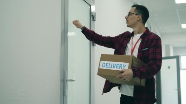 Мужчина достает коробки для доставки из багажника машины — стоковое видео