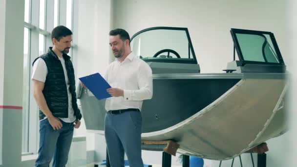 Due uomini stanno discutendo l'acquisto di un motoscafo. — Video Stock