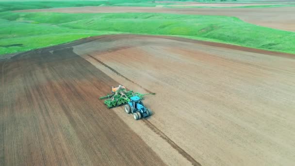 Vast field is getting sawn by an agricultural machine — Stock Video