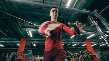 Bir adam spor yaparken spor yapmak için spor aleti kullanıyor.