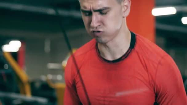 En man i fitnesscentret tränar med ansträngning — Stockvideo
