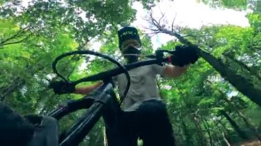 Bisikletin direksiyonundaki bisikletçinin ön görüntüsü.