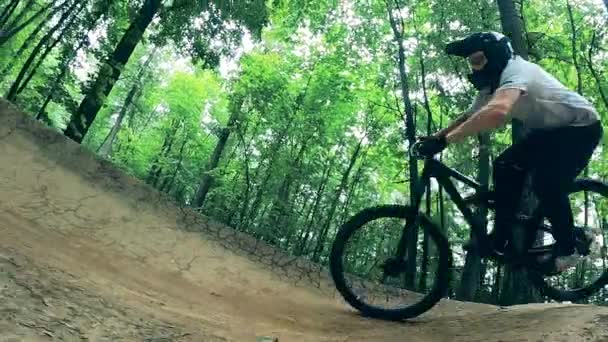 Ciclista está se movendo sobre solavancos na floresta — Vídeo de Stock