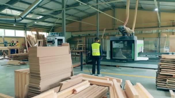 El hombre trabaja en la fábrica de madera. — Vídeos de Stock