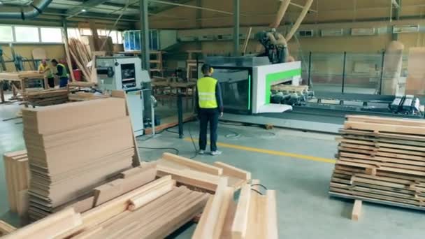 Trabajador masculino comprueba madera fábrica máquina de corte de madera. — Vídeos de Stock