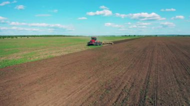 Çalışan bir traktör, tarla sürme alanı görüntüsü.