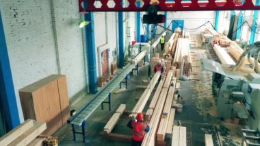 Erkekler tesise kereste yığar..