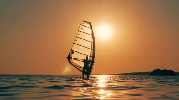 Windsurfer cruza el mar al atardecer — Vídeos de Stock