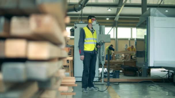 Один инженер в форме работает на деревообрабатывающем заводе. — стоковое видео