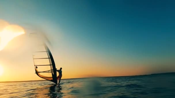 Sunset sea and a windsurfer managing a sailboard — Stock Video