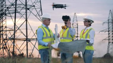 Elektrik mühendisleri VR gözlükleri ve İHA 'sı olan bir projeyi inceliyorlar.