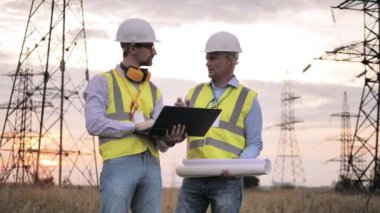 Erkek mühendisler şanzıman kuleleriyle konuşuyorlar.