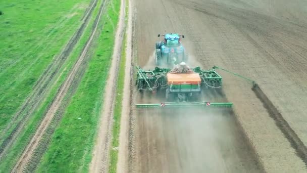 Zielony traktor pracuje na polu, orając glebę. — Wideo stockowe