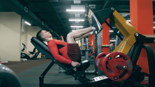 Sportowiec używa urządzenia fitness, by utrzymać sprawność nóg. — Wideo stockowe