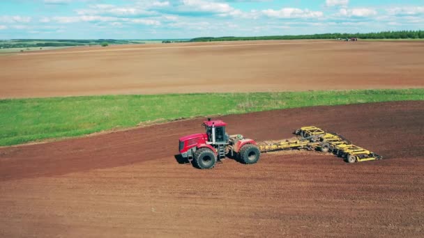 Máquinas con equipo de arado trabajan en un campo de cultivo. — Vídeo de stock