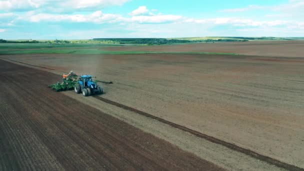 Az egyik traktor szántja a földet egy farmon vetőmagok ültetésére. — Stock videók