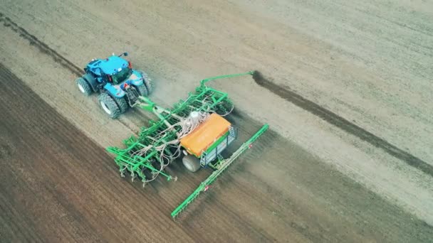 Un trattore cavalca su un campo, arando per semina. — Video Stock
