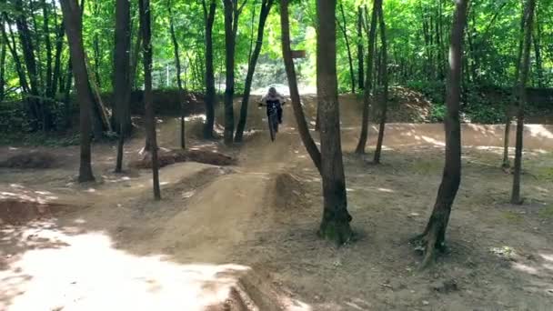 Trilho de bicicleta da floresta e um cavaleiro masculino passando por ele — Vídeo de Stock