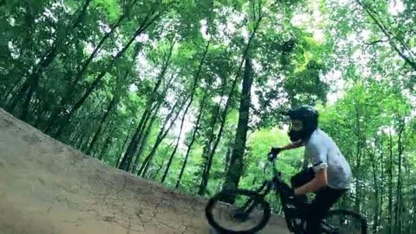 Ciclista masculino está andando ao longo das bordas de uma trilha florestal — Vídeo de Stock