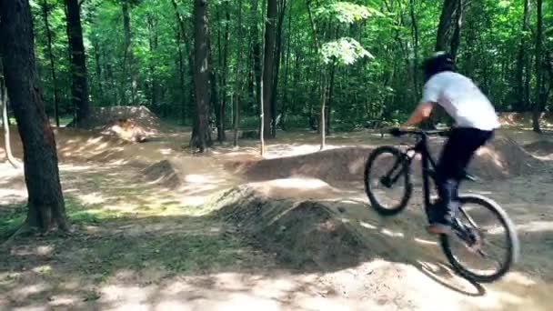 Muž cyklista dělá špínu skákání na lesní cestě — Stock video