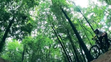 Bisiklet sürücüsü bisikletle doğal rampalardan geçiyor.