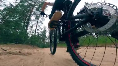 Ormandaki bir BMX 'te bisiklet süren bir adamın arkadan görünüşü