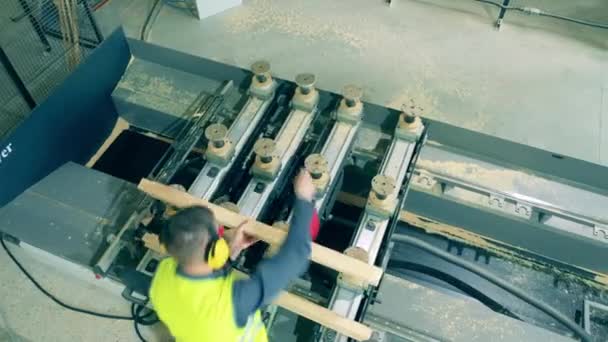 Ingeniero está examinando las balas de madera procesadas por la máquina — Vídeo de stock