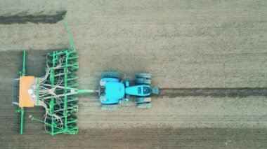 Çalışan traktör, çiftliği ekime hazırlamak için tarlayı sürüyor..