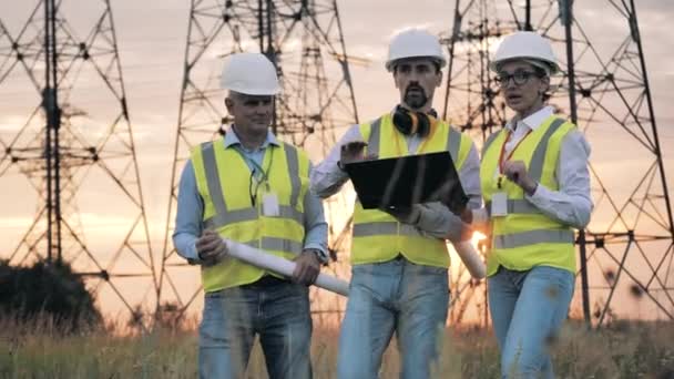 Spezialisten sprechen neben Stromtrassen — Stockvideo