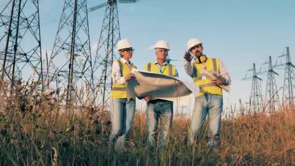 Elektriciteitsingenieurs bespreken een nieuw project in de open lucht — Stockvideo