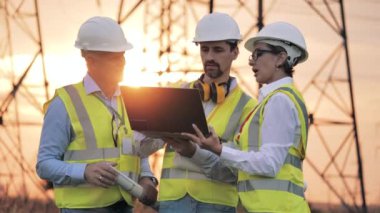 Enerji tasarrufu, enerji verimliliği kavramı. Bir grup enerji mühendisi gün batımında tartışıyorlar.