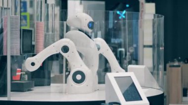 Robot kafede kahve yapan bir makineyi yönetiyor.